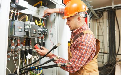 young adult electrician builder engineer worker in front of fuse switch board